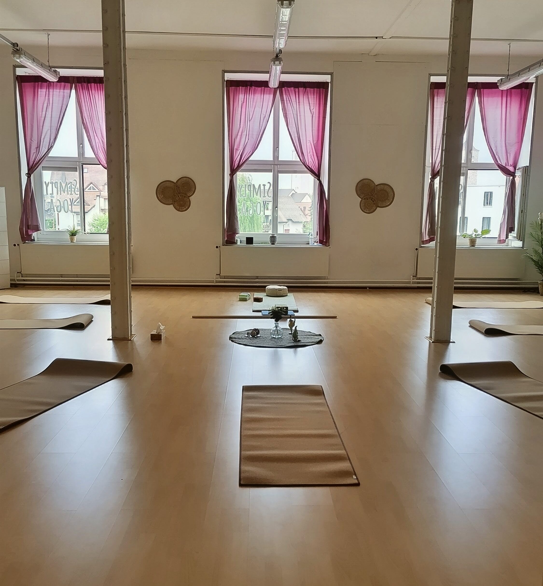 Heller Yogaraum bei Simply Yoga mit vorbereiteten Matten